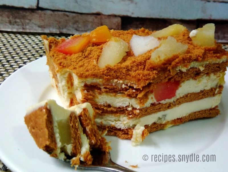 A fruit cocktail cake with a cone in between spilling fruits on cake –  Creme Castle